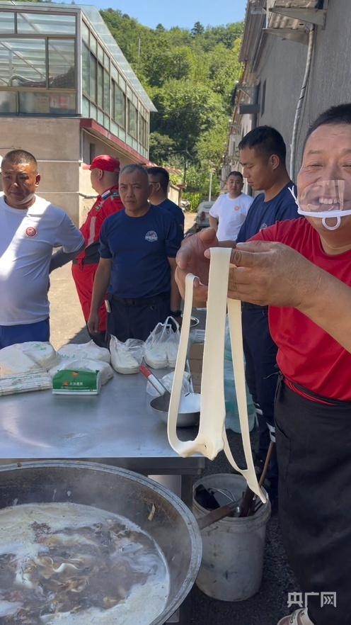 赵占胜（右）一边扯面一边和村民聊天（央广网发 受访者供图）
